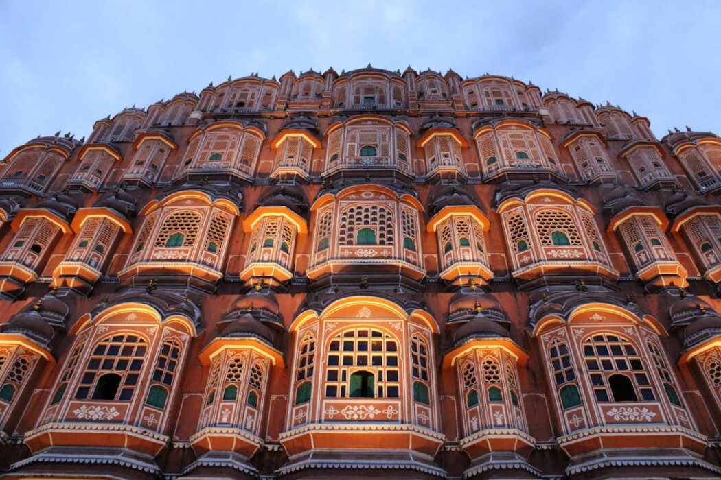 Low angle shot of Hawa Mahal's illuminated facade in Jaipur, showcasing its intricate Hindu architecture.