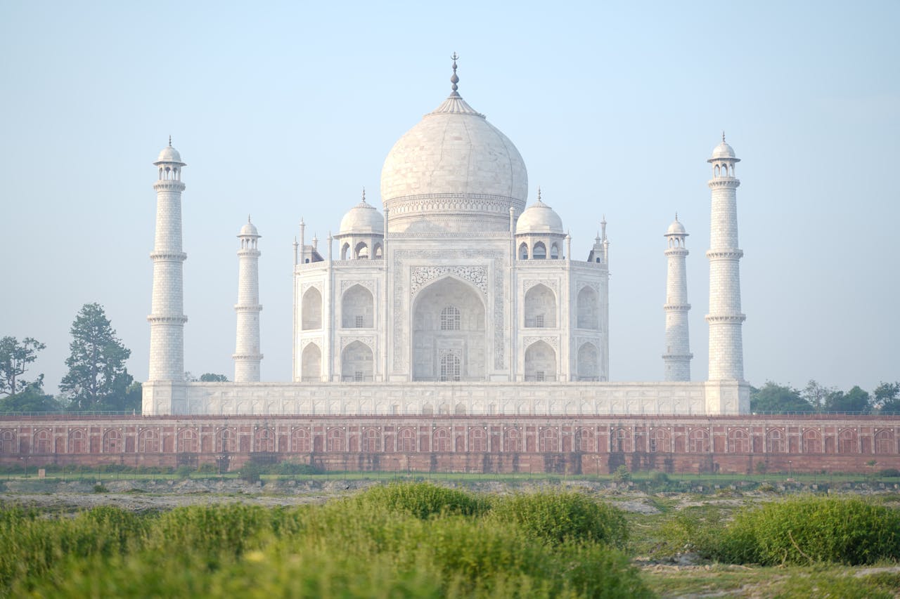 Elegant capture of the Taj Mahal in Agra, India, showcasing its iconic dome and minarets at sunrise.